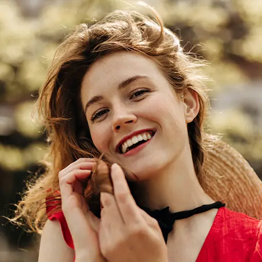 attractive happy woman in red dress smiling outdoo UW49SNL.jpg