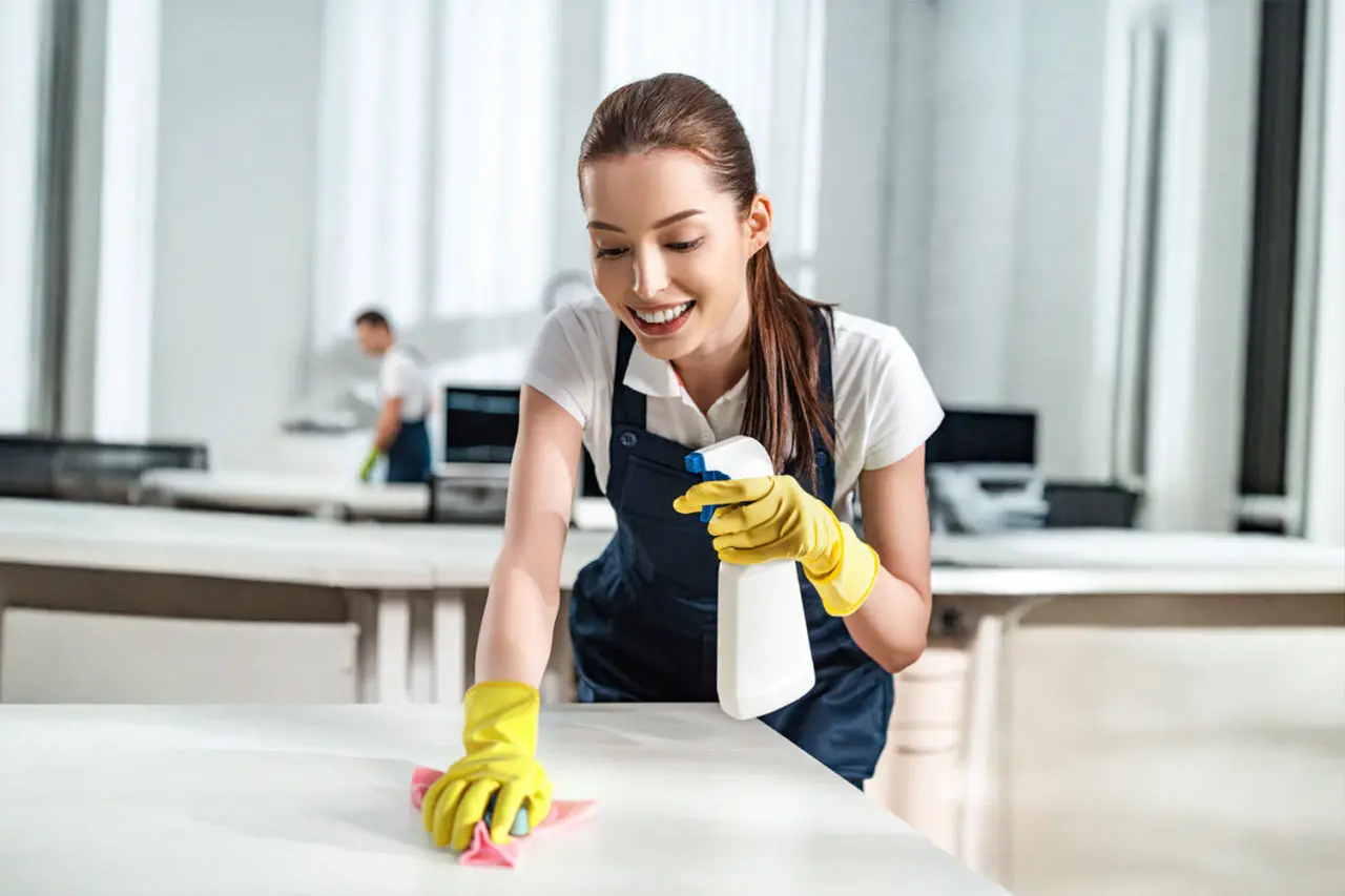 happy cleaner holding spray bottle while washing d M2UXGTR.jpg